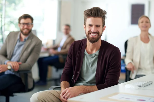 A liderança moderna parece cheia de promessas. Profissional criativo sorridente com colegas em segundo plano. — Fotografia de Stock