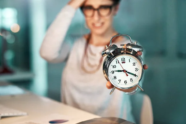 Não há tempo suficiente para completar os prazos iminentes. Tiro de uma jovem empresária segurando um relógio se preocupando com seu prazo no escritório. — Fotografia de Stock