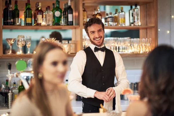 Hij houdt gewoon van zijn werk. Gehakt schot van een knappe jonge ober glimlachend terwijl hij in een bar staat. — Stockfoto