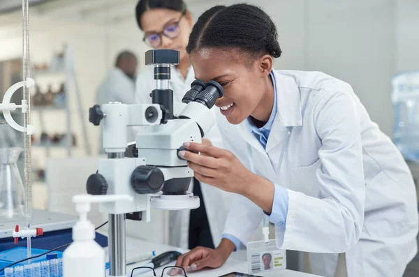 Wetenschap laat je veel meer zien. Foto van een jonge wetenschapper met behulp van een microscoop in een lab. — Stockfoto