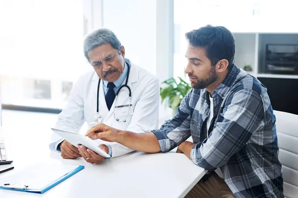Wanneer zag je voor het laatst een dokter? Schot van een volwassen mannelijke arts en patiënt met een discussie in het kantoor van de arts voor een controle. — Stockfoto