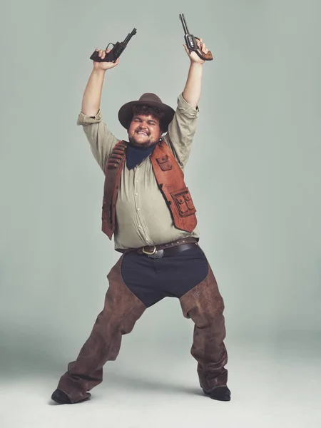一个超重的牛仔满面春风 拿着手枪在空中飞舞 — 图库照片
