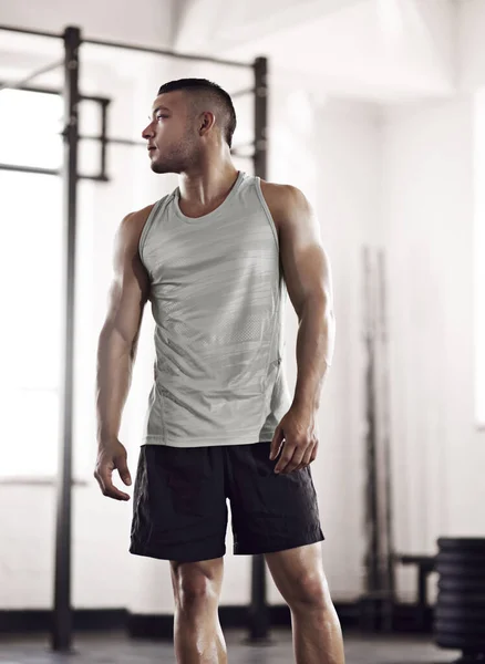 Pasemos al siguiente ejercicio. Recorte de un joven haciendo ejercicio en el gimnasio. —  Fotos de Stock