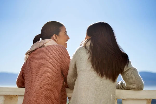Sdílíme všechno. Dvě mladé ženy stojící venku na balkóně a přátelsky si povídají. — Stock fotografie