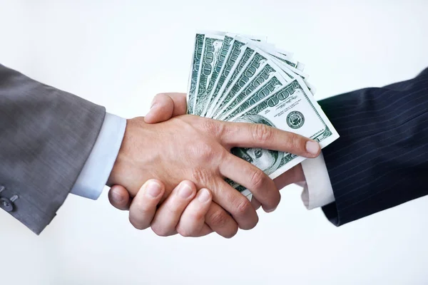 If you do this for me.... Studio shot of two men shaking hands after making a monetary deal. — Stock Photo, Image