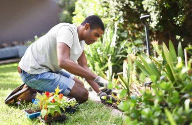Rooting out the problem. Cropped shot of a handsome young man gardening. clipart
