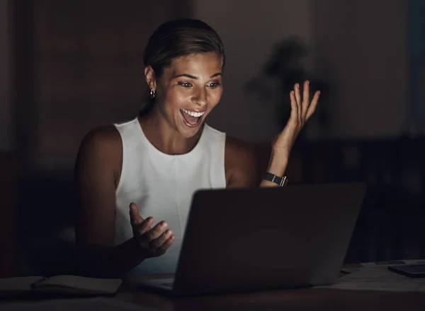 Její čas stál za každý desetník. Snímek mladé podnikatelky pomocí notebooku a vypadající překvapeně během pozdní noci v práci. — Stock fotografie