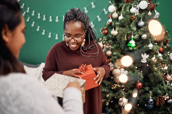 Não se esqueça de apreciar o melhor presente de sempre... amizade. Tiro de duas jovens felizes trocando presentes durante o Natal em casa. — Fotografia de Stock