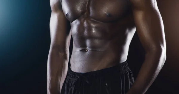 El cuerpo que desea es un par de entrenamientos de distancia. Captura de estudio de un atleta masculino sin camisa no reconocido posando sobre un fondo oscuro. —  Fotos de Stock