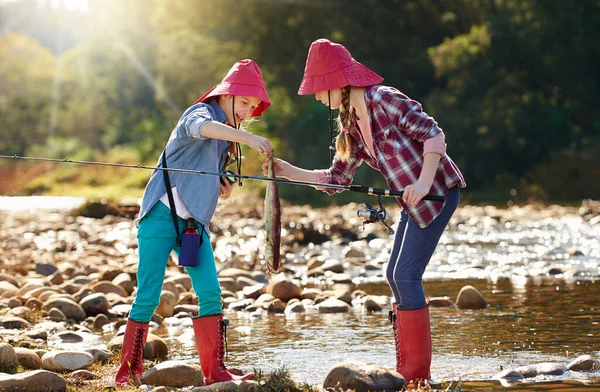 Balıkçı arkadaşlar eğleniyor. Nehir kenarında balık tutan iki genç kızın fotoğrafı.. — Stok fotoğraf