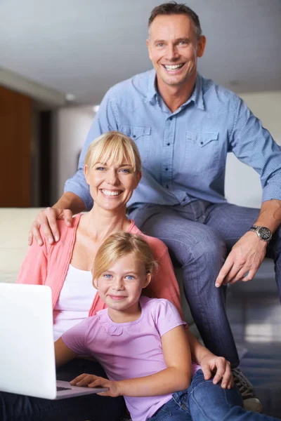 Vinculación familiar. Una familia de tres usando un portátil en el salón. — Foto de Stock