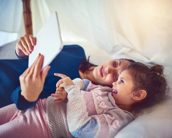 İnteraktif öğrenme zamanı. Evde dijital tablet kullanan bir anne ve küçük kızının fotoğrafı.. — Stok fotoğraf
