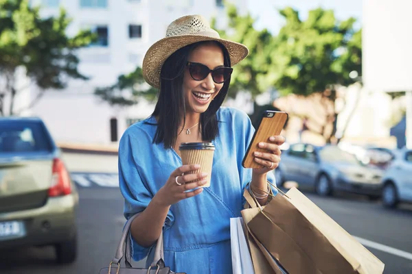 Non crederete che una grande vendita mi sono imbattuto in oggi.... Colpo ritagliato di una giovane donna attraente sorridente durante l'utilizzo di uno smartphone dopo una furia shopping in città. — Foto Stock