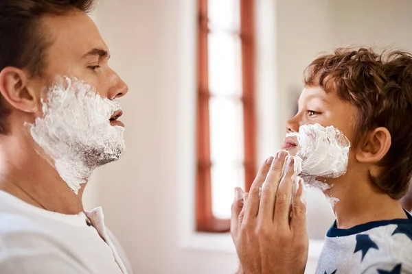 Nejdřív se musíme umýt. Zastřelen, jak muž učí svého malého syna, jak se doma holit. — Stock fotografie