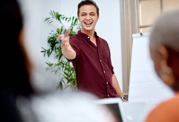 Ele sabe como inspirar e elevar sua equipe. Tiro de um jovem empresário usando um quadro branco ao fazer uma apresentação para seus colegas em um escritório. — Fotografia de Stock