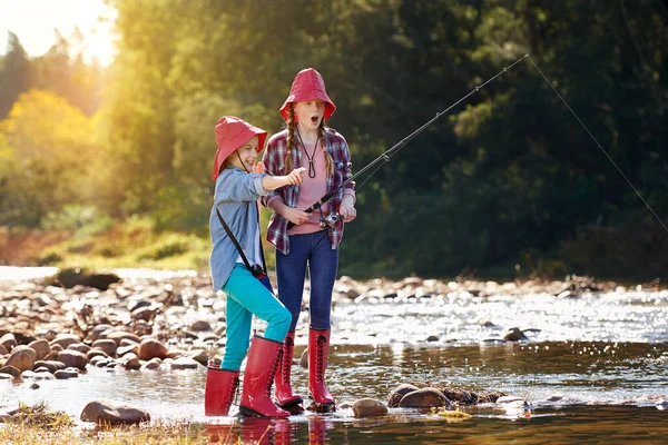 Apanhámos um. Tiro de duas meninas pescando por um rio. — Fotografia de Stock