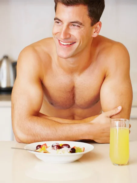 Budování dokonalého těla se zdravou snídaní. Vystřižený záběr svalnatého muže jíst snídani. — Stock fotografie