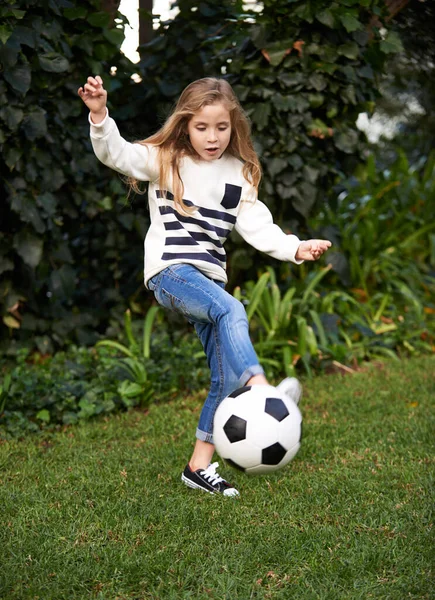 Ze heeft enige vaardigheid. Shot van een klein meisje spelen met een voetbal in een tuin. — Stockfoto