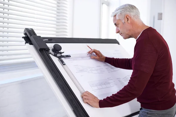 En iyi yaptığı şeyi yapıyor. Bir erkek mimarın çizim tahtasında bina planı üzerinde çalışırken çekilmiş görüntüsü.. — Stok fotoğraf