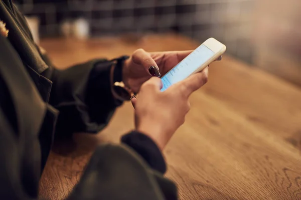 Mettiti in contatto, resta in contatto. Foto ritagliata di una donna che usa il cellulare in un bar. — Foto Stock