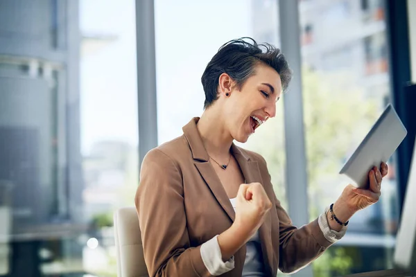 Τα κέρδη μας αυξάνονται. Shot of a business woman doing a fist pump while working on a digital tablet in a office. — Φωτογραφία Αρχείου