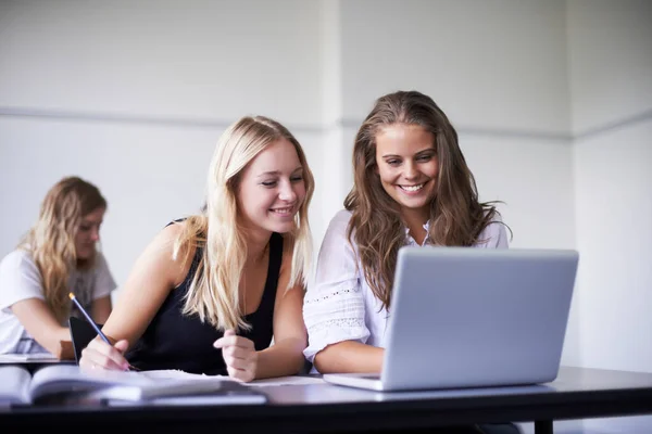 Každý den se učí nové věci. Dvě nádherné dospívající dívky pracující na notebooku ve třídě. — Stock fotografie