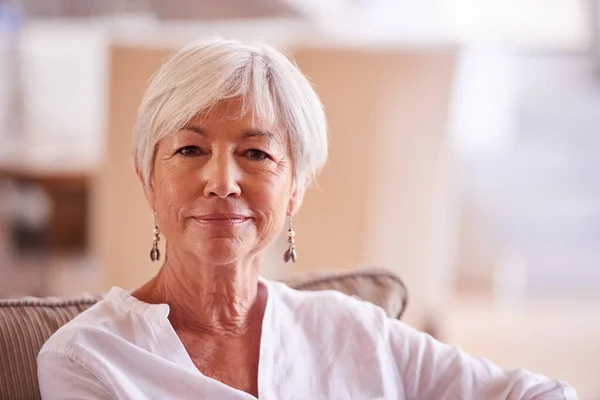 Confident in her golden years. Portrait of a senior woman sitting indoors. — Stock Photo, Image