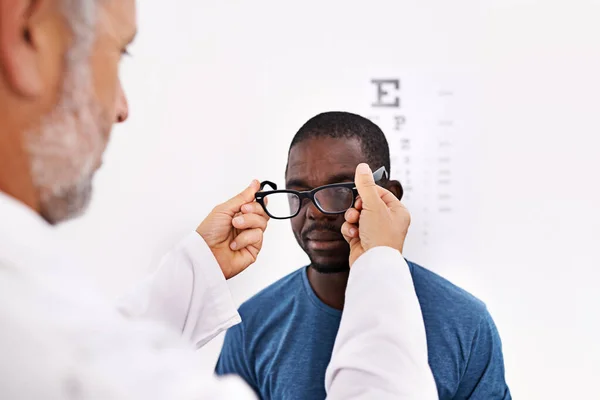 Mensen duidelijk laten zien. Gehakte opname van een optometrist die het gezichtsvermogen van een patiënt test. — Stockfoto