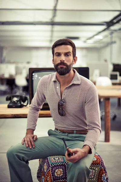 Een retro-feel naar kantoor brengen. Een zakenman in retro kleding zit aan een bureau met een pijp. — Stockfoto