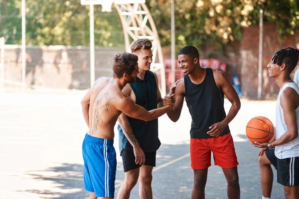 Jag hyllar dina färdigheter på planen idag. Skjutna av en grupp sportiga unga män som hälsar på varandra på en basketplan. — Stockfoto