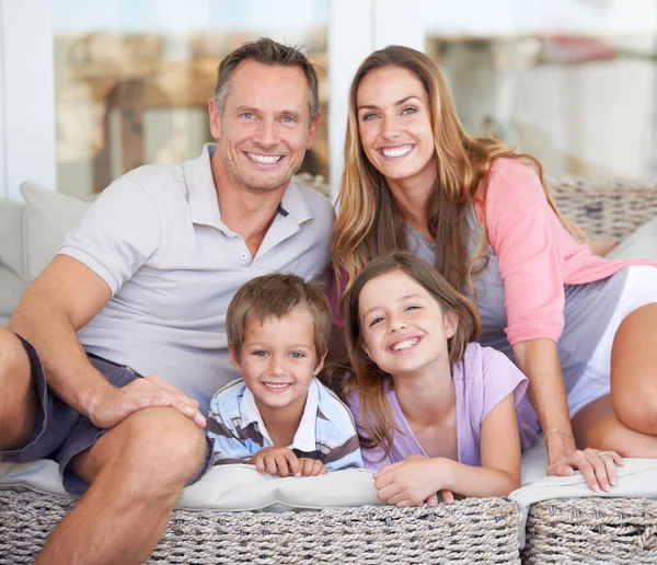 Představte si dokonalou rodinu. Portrét šťastné mladé čtyřčlenné rodiny sedící spolu na terase. — Stock fotografie