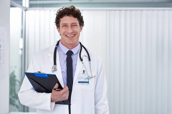 Mudar vidas um dia de cada vez. Tiro recortado de um médico bonito sorrindo feliz para a câmera. — Fotografia de Stock