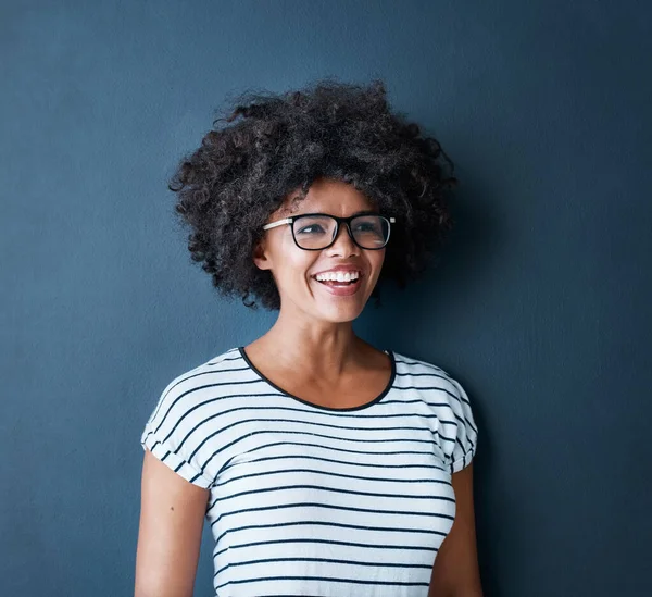 De goede kant van het leven zien. Studio shot van een aantrekkelijke en gelukkige jonge vrouw met een bril tegen een blauwe achtergrond. — Stockfoto