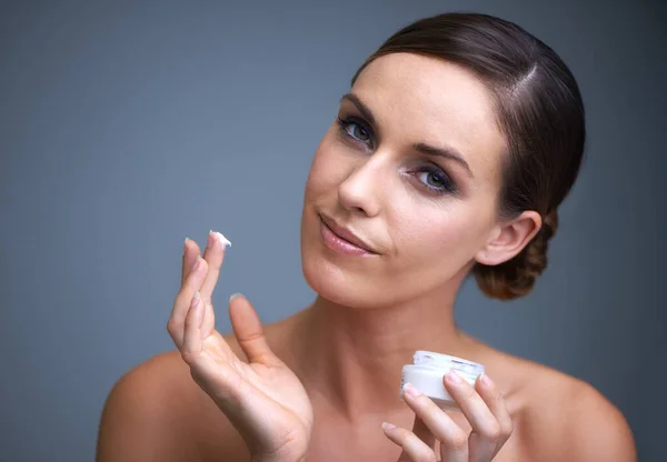 Mantenere sana la sua pelle. Ritratto di una giovane donna attraente che applica crema idratante sulla sua pelle. — Foto Stock