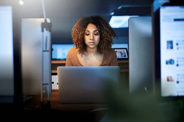 100 dedicated to her deadline. Shot of a young woman working late in an empty office. — Stock Photo, Image