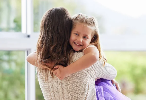 Ik hou van haar knuffeltjes. Shot van een klein meisje geven haar moeder een knuffel thuis. — Stockfoto