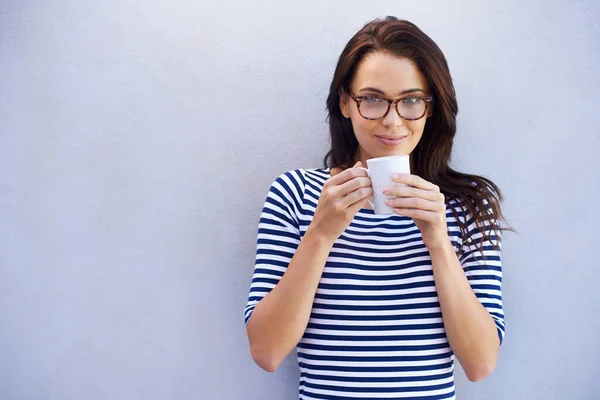 Отличный напиток. Портрет привлекательной женщины, держащей чашку кофе на сером фоне. — стоковое фото