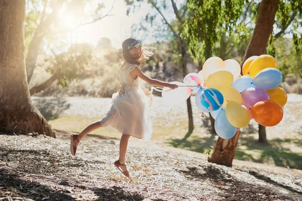 Debout, debout et loin. Tourné d'une petite fille jouant avec un tas de ballons à l'extérieur. — Photo