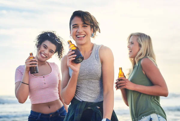 Levamos a festa para onde formos. Tiro de três amigos desfrutando de bebidas enquanto na praia. — Fotografia de Stock