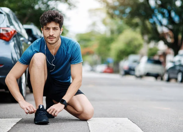 Cordones atados y listos para despegar. Tiro de un joven deportivo atándose los zapatos antes de salir a correr durante el día.. —  Fotos de Stock