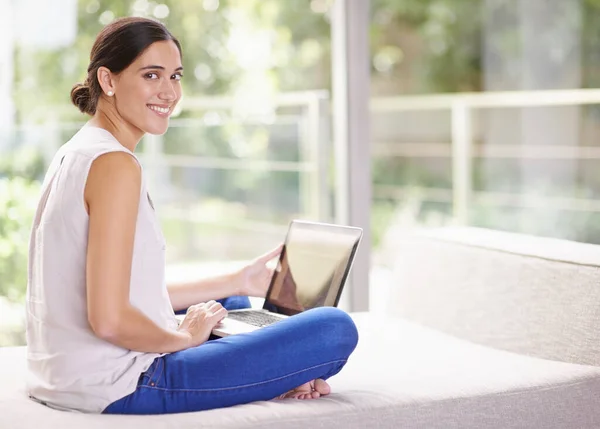 Мой Wi-Fi позволяет мне просматривать, где я хочу. Съемка привлекательной молодой женщины с помощью ноутбука во время отдыха дома. — стоковое фото