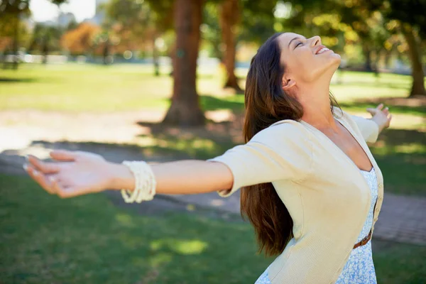 Portare tutto dentro. Girato di una giovane donna spensierata che si gode una giornata al parco. — Foto Stock