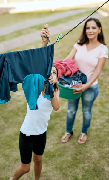 Imparare ad essere responsabili uno alla volta. Girato di una madre e figlia appendere lavanderia insieme fuori. — Foto Stock