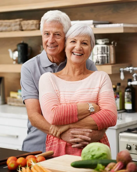 Je ferais n'importe quoi pour elle, j'apprendrais même à cuisiner. Tourné d'un beau couple de personnes âgées posant affectueusement dans une cuisine. — Photo