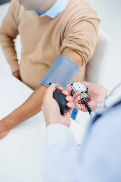 Checking his blood pressure. High angle shot of a male doctor taking a patients blood pressure. — Stock Photo, Image