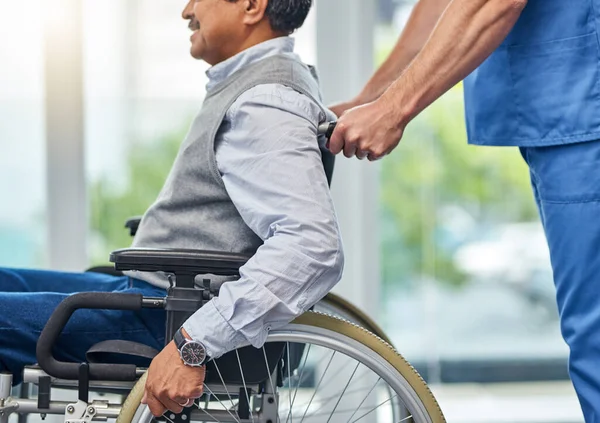 Poner su gestión de la movilidad en manos expertas. Fotografía de una enfermera ayudando a un hombre mayor en silla de ruedas. — Foto de Stock