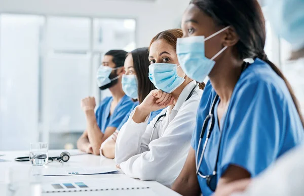 Die Integration der Ärzte wird in diesem Fall von entscheidender Bedeutung sein. Porträt einer Ärztin, die neben ihren Kollegen während einer Besprechung im Vorstandssaal eines Krankenhauses sitzt. — Stockfoto