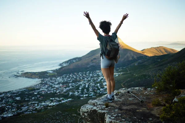 私はそれを一番上までやりました。山の崖の上に立っている間、彼女の腕を伸ばして立っている女性のショット. — ストック写真