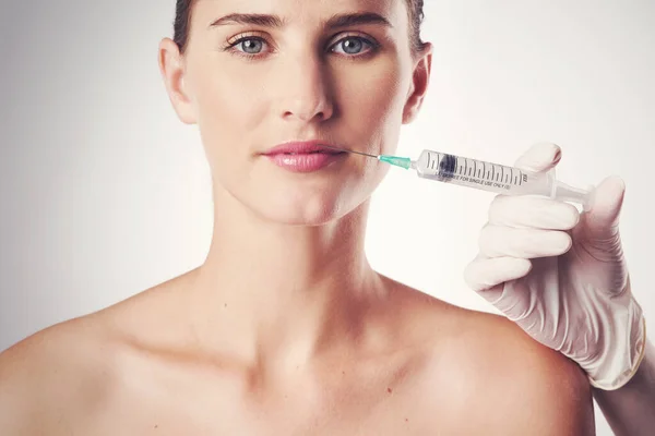 Gagner la guerre contre le vieillissement. Plan studio d'une jeune femme séduisante faisant une injection à des fins cosmétiques. — Photo