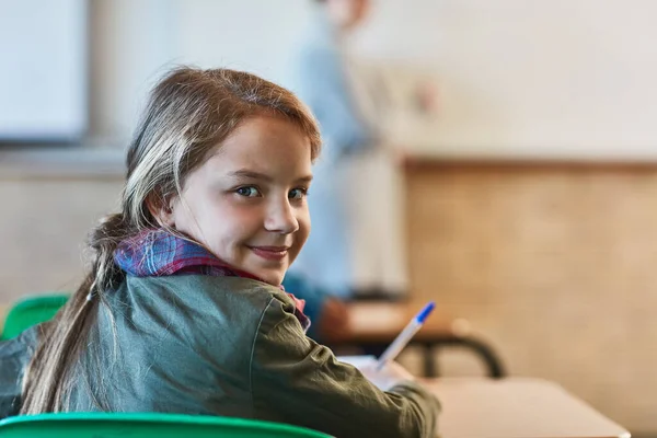 学校はクールで、彼女はそれを愛しています。教室で小学生の女の子を切り取った. — ストック写真